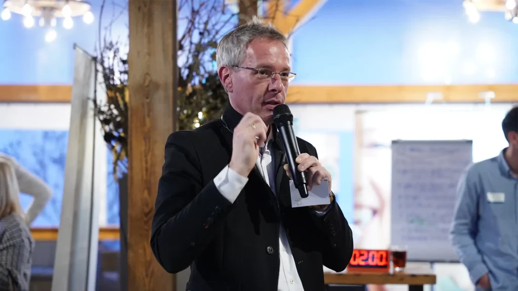 Ein Referent erklärt Inhalte zur Kiefermuskulatur mit einem Mikrofon während einer Fachveranstaltung.